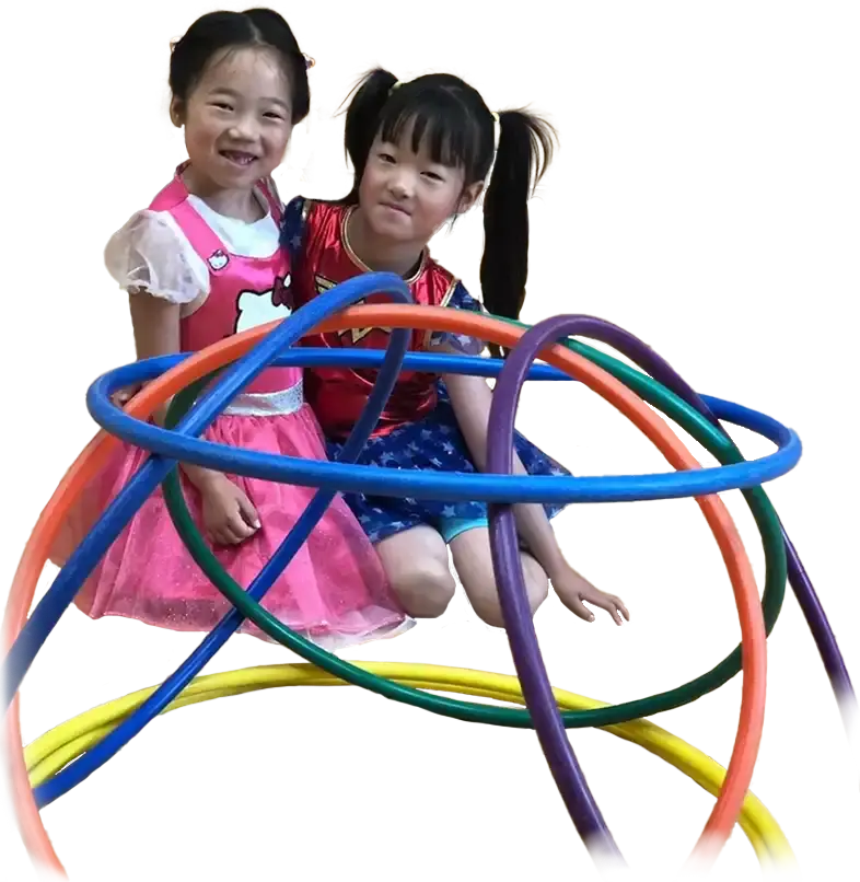 Two school girls building a structure out of hula hoops
