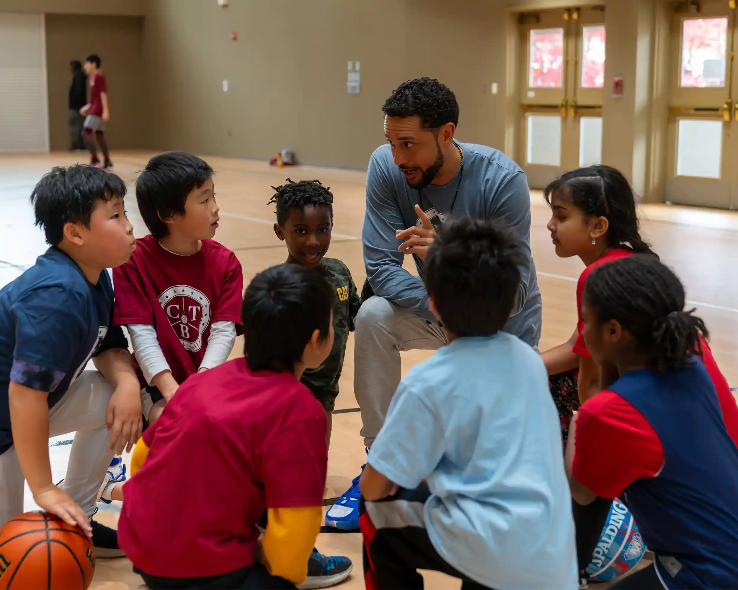 A basketball coach in the huddle with young kids