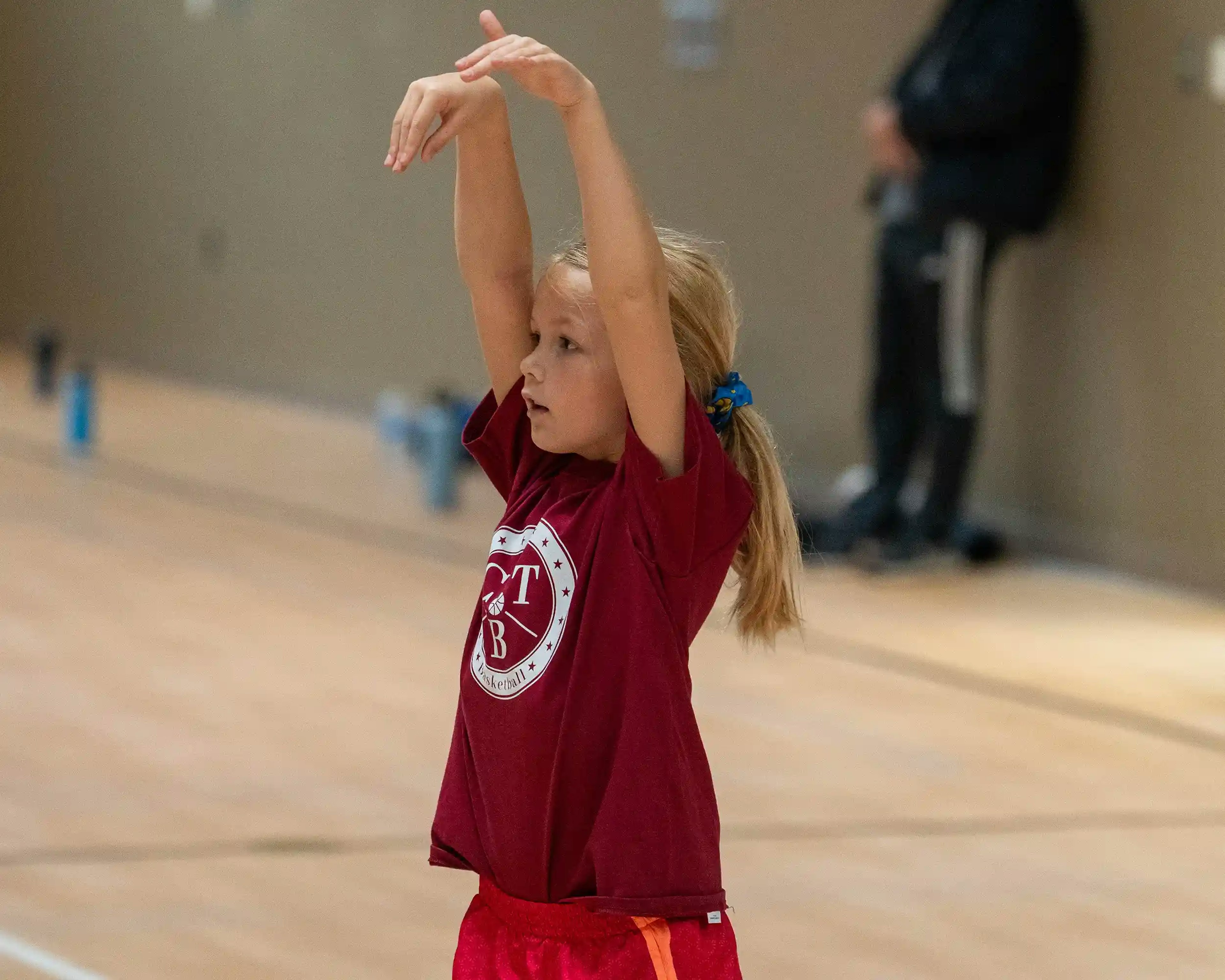 A young girl learning basketball shooting form